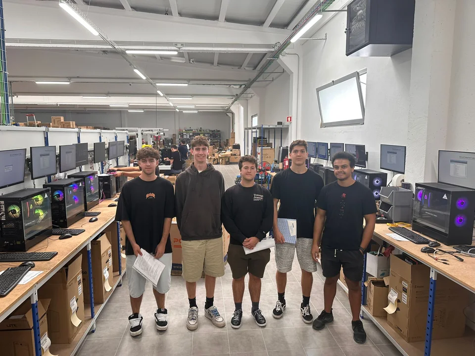 Six students standing in a computer assembly and service workspace in Leiria